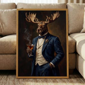May include: A framed wall art print featuring an anthropomorphic moose dressed in a formal navy blue suit, a cream-colored vest, and a dark bowtie. The moose holds a glass of amber liquid with rising smoke, set against a dark, moody background.