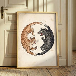 Könnte beinhalten: Ein gerahmter Kunstdruck mit einer Illustration von zwei Katzen in einer kreisförmigen Yin-Yang-Anordnung. Eine Katze ist orange getigert, die andere dunkelgrau getigert. Beide Katzen zeigen ihre Zähne und Krallen in einer dynamischen Pose.