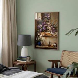 K&ouml;nnte beinhalten: Ein gerahmtes Kunstwerk zeigt eine rot getigerte Katze, die in einer Vintage-Badewanne mit Blumen schl&auml;ft. Das Gem&auml;lde hat eine rustikale &Auml;sthetik mit einem Holzrahmen, einer blauen Vase und einem kleinen Tisch mit Seife und Flaschen.