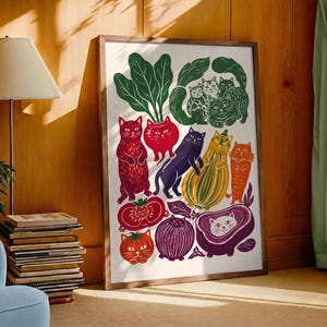 May include: A framed rectangular art print featuring a whimsical illustration of various cats integrated with vegetables and fruits. The colorful design includes red, green, purple, orange, and yellow stylized cats shaped like produce on a white background.