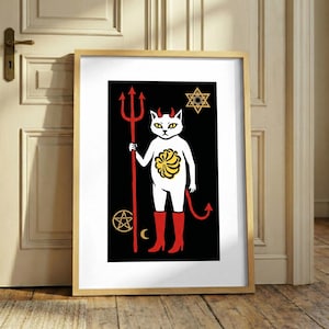 Op de afbeelding: Een ingelijste kunstdruk met een witte kat met rode hoorns en een rode staart, die rode laarzen draagt. De kat houdt een rode drietand vast tegen een zwarte achtergrond. Symbolen zijn een gele ster, een geel pentagram en een gele maansikkel.
