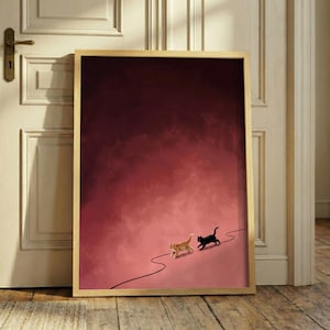 May include: A framed art print featuring two cats, one orange and one black, walking along a winding black line against a gradient red and pink background. The artwork is displayed in a room with a wooden door and floor.