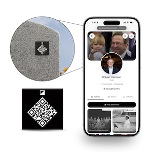 May include: A smartphone displaying a memorial profile for Robert Harrison, featuring a circular portrait, dates, and photo gallery. A circular inset shows a black square QR code sticker attached to a gray granite headstone surface.