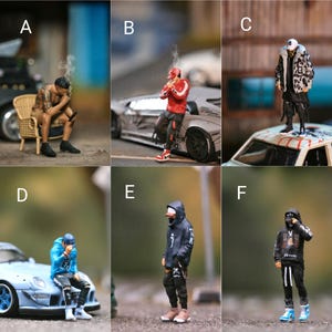 May include: Six miniature figures in various poses, wearing different clothing and accessories. The figures are posed in front of different backgrounds, including a car, a building, and a grassy area.