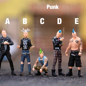 Può includere: Un gruppo di cinque miniature punk rock con acconciature mohawk colorate e abbigliamento alternativo. Le figure sono etichettate dalla A alla E, con la parola "Punk" sopra. Sono posizionate su una superficie scura.