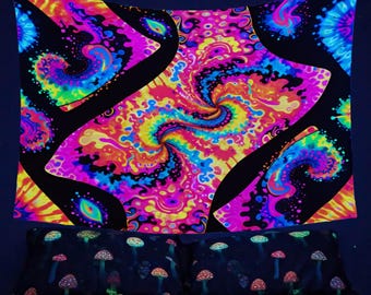 May include: A black tapestry with a psychedelic design featuring swirling colors of pink, blue, yellow, and orange. The tapestry is hanging on a wall above a bed with a black and white mushroom print.