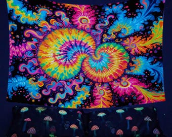 May include: A psychedelic tapestry with a black background and a swirling tie-dye pattern in bright colors like pink, blue, yellow, and orange. The tapestry is hanging on a dark blue wall above a bed with a mushroom print.