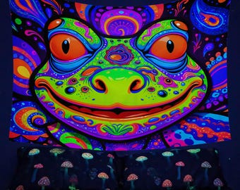 May include: A psychedelic tapestry featuring a green frog with orange eyes and a wide smile. The frog is surrounded by colorful swirls and patterns. The tapestry is perfect for adding a touch of whimsy to any room.