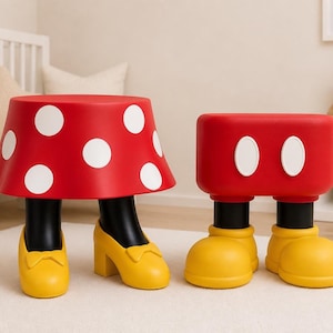 May include: Two whimsical red and white polka dot stools. One stool is shaped like a skirt with black legs and yellow heels. The other stool is a red rectangle with white ovals and yellow shoes.