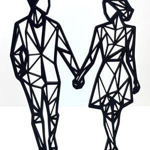 May include: A black geometric sculpture of a couple holding hands. The figures are stylized with angular shapes, standing on a rectangular base. The sculpture is made of a solid black material and set against a white background.