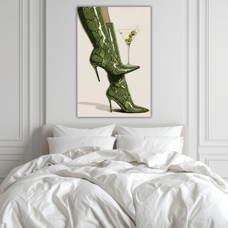 Op de afbeelding: Een artistieke print met een paar groene, slangenleer-achtige hoge hakken en een martini glas met olijven. De laarzen hebben stilettohakken en spitse tenen. Het martini glas voegt een vleugje elegantie toe.