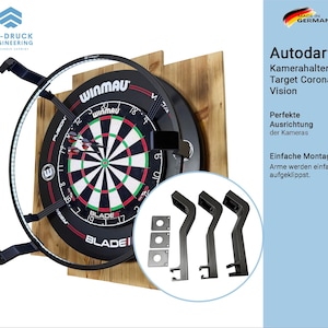 May include: A dartboard with a black and red design, surrounded by a black metal frame with LED lights. The board is mounted on a wooden backing. The image includes the text "Autodarts" and "Made in Germany".