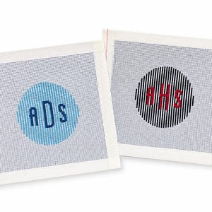 Puede incluir: Dos lienzos cuadrados de punto de aguja con bordes blancos. El lienzo izquierdo presenta un círculo azul claro con las letras azules ADS. El lienzo derecho muestra un círculo de rayas blancas y negras con las letras rojas AHS en el centro.