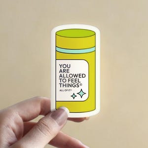 Könnte beinhalten: Ein Aufkleber in Form einer Pillenflasche mit gelbem und grünem Design. Der Aufkleber trägt den Text "YOU ARE ALLOWED TO FEEL THINGS" und zwei blaue Sterne.