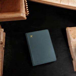 Funda minimalista de cuero negro para pasaporte con icono de avión dorado - Billetera de viaje para hombres y mujeres - Funda delgada para pasaporte - Idea de regalo