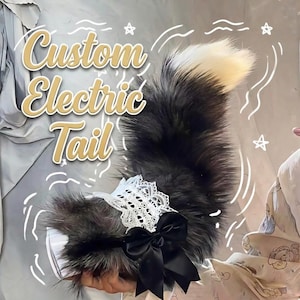 May include: A custom electric tail with a fluffy, dark gray and white design. The tail features a white lace trim and a black satin bow. The text "Custom Electric Tail" is displayed in a gold, outlined font.