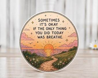 Könnte beinhalten: Ein runder Aufkleber mit einer Sonnenuntergangsszene, einem Pfad und dem Text: "Sometimes it's okay if the only thing you did today was breathe." Das Design zeigt einen Sonnenuntergang über dem Wasser, mit Wolken, Vögeln und einem Pfad.