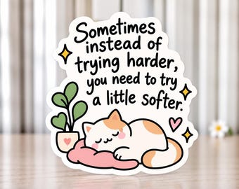 Könnte beinhalten: Ein gestanzter Aufkleber mit einer schlafenden weiß-orangen Katze auf einem rosa Kissen neben einer grünen Topfpflanze. Der Text lautet: Sometimes instead of trying harder, you need to try a little softer. Das Design enthält gelbe Sterne und ein rosa Herz.