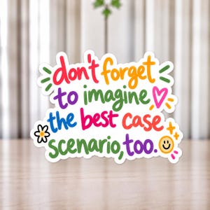 Può includere: Un adesivo fustellato con il testo colorato "don't forget to imagine the best case scenario, too." Il design include un cuore rosa, un piccolo fiore bianco, scintille gialle e un'icona a forma di faccina sorridente gialla su sfondo bianco.