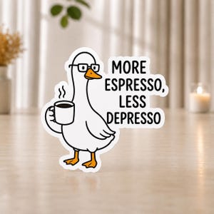Könnte beinhalten: Ein weißer, konturgestanzter Aufkleber mit einer Cartoon-Gans, die eine schwarz umrandete Brille trägt und eine dampfende weiße Kaffeetasse hält. Rechts neben der Gans steht der Text MORE ESPRESSO, LESS DEPRESSO in fetten schwarzen Großbuchstaben.