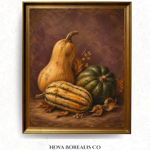 May include: A framed oil painting depicting a still life of three gourds in shades of yellow, green, and tan, arranged on a dark surface with dried leaves. The artwork is enclosed in a metallic gold frame and features the text NOVA BOREALIS CO.