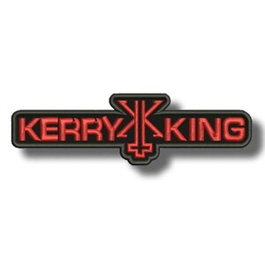 May include: Embroidered patch with the name "KERRY KING" in red, edged in black. A red stylized symbol is positioned between the words, set against a black rectangular backdrop.