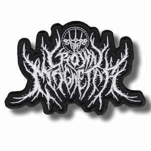 Könnte beinhalten: Schwarz-weißer, gestickter Aufnäher mit dem Text "CROWN OF MADNESS" in einer stilisierten, gotischen Schriftart. Der Aufnäher hat ein detailliertes, kompliziertes Design mit einem kreisförmigen Emblem oben. Der Aufnäher ist etwa 10 cm breit.