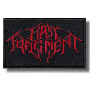 Pode incluir: Patch retangular preto com as palavras "FIRST FRAGMENT" bordadas em vermelho, com letras de estilo gótico. O patch tem uma borda preta e é projetado para ser costurado ou passado a ferro em roupas ou acessórios.