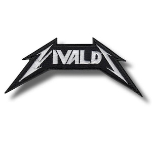 May include: Black and white embroidered patch with the word "VALD" in bold, stylized lettering. The patch has a unique, angular shape with pointed edges and white stitching. The patch is likely for clothing or accessories.