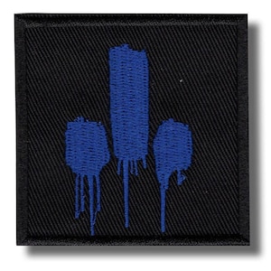 Könnte beinhalten: Quadratischer schwarzer Aufnäher mit einem blauen abstrakten Design. Das Design zeigt drei blaue Formen mit tropfenden Farbeffekten. Der Aufnäher hat einen schwarzen Rand und ist wahrscheinlich ein gestickter oder gewebter Artikel.