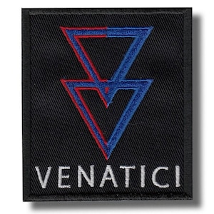 May include: Black embroidered patch featuring a stylized geometric design in blue and red, with the word "VENATICI" in white capital letters. The patch has a rectangular shape and a black border.