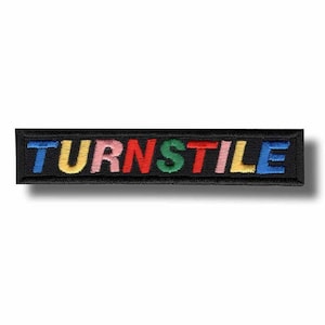 Peut inclure: Écusson brodé avec le mot "TURNSTILE" en lettres multicolores. Le texte est en bleu, jaune, rose, rouge, vert et bleu, cousu sur un fond rectangulaire noir. Idéal pour les vêtements ou les accessoires.