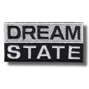 Op de afbeelding: Geborduurd rechthoekig embleem met de woorden "DREAM STATE" in witte letters. De bovenste helft is lichtgrijs, de onderste helft zwart. Geschikt voor het personaliseren van kleding.