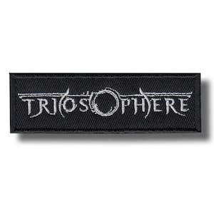 Puede incluir: Parche rectangular negro con la palabra "TRIOSPHERE" bordada en blanco, con letras estilizadas. El diseño incluye un elemento circular. El parche es probablemente para ropa o accesorios.