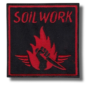 Puede incluir: Parche cuadrado negro con borde rojo y texto "SOIL WORK". El parche presenta un diseño de llama roja con un puño negro sosteniendo un cuchillo. Probablemente está diseñado para coser en la ropa.