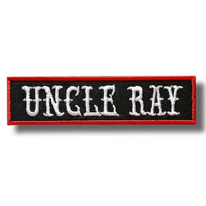 Può includere: Toppa ricamata rettangolare con la scritta "UNCLE RAY" in bianco, con caratteri gotici. La toppa ha uno sfondo nero e un bordo rosso. Ideale per giacche, borse o altri articoli in tessuto.