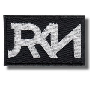 以下が含まれることがあります： 黒い長方形のパッチで、白い刺繍文字「RM」が施されています。文字は様式化され太字で、テクスチャード加工が施されています。パッチは黒い縁取りがあり、布に縫い付けたりアイロンをかけたりするように設計されています。