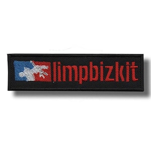 Puede incluir: Parche negro bordado con el nombre de la banda "limpbizkit" en letras rojas. Un diseño azul y rojo con un gráfico blanco está en la izquierda. El parche es rectangular.