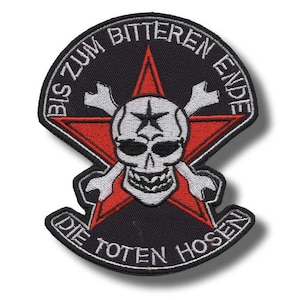 May include: Black patch with a red star, a skull with a star on its forehead, and crossed bones. The patch has the text "BIS ZUM BITTEREN ENDE" and "DIE TOTEN HOSEN" in white lettering.