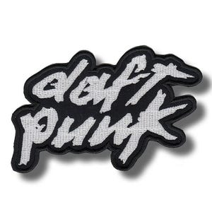 May include: A black and white embroidered patch with the words "Daft Punk" in a cursive font. The patch has a black border and is designed to be sewn or ironed onto clothing or accessories. A music-themed item.
