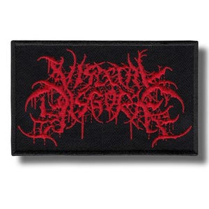 May include: Black rectangular patch with red embroidered text. The text is stylized and appears to be a band logo. The patch has a black border and is likely made of fabric.