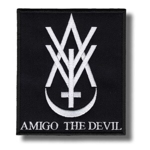 May include: Black square patch with a white embroidered design. The design includes a stylized symbol with a cross, crescent moon, and the text "AMIGO THE DEVIL". Suitable for clothing or accessories.