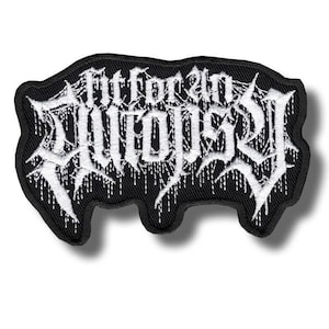 Puede incluir: Parche bordado negro con el texto "Fit for an Autopsy" en blanco, con letras góticas. El parche tiene un borde negro y una forma irregular. El diseño presenta efectos de goteo.
