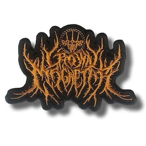 May include: Embroidered patch with a black backing and gold-coloured text and design. The design features the text "Crown Magnetar" in a stylized font, with a circular emblem at the top. The patch has a unique, irregular shape.