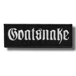 Peut inclure: Écusson rectangulaire noir avec le mot "Goatsnake" brodé en blanc dans une police gothique. Le patch a une bordure noire et est probablement conçu pour être cousu sur des vêtements ou des accessoires.