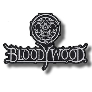 Może przedstawiać: Czarna i biała naszywka z haftem przedstawiająca nazwę zespołu "BLOODYWOOD" w stylizowanej czcionce. Nad tekstem znajduje się okrągły emblemat z motywem słonia. Naszywka ma ozdobną obwódkę.
