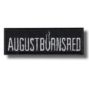 Peut inclure: Écusson rectangulaire noir avec le texte brodé "AUGUSTBURNSRED" en blanc. L'écusson a une bordure noire et un effet d'ombre.