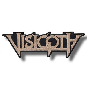以下が含まれることがあります： 黒いワッペンに「VISIGOTH」の文字がベージュ色で刺繍されています。ワッペンは独特の書体で、黒い縁取りがあります。このワッペンは、衣類やアクセサリー用である可能性があります。