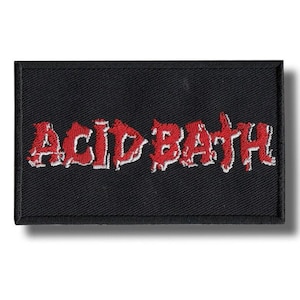 May include: Black rectangular patch with the embroidered text "ACID BATH" in red with white outlining. The patch is likely for a jacket or bag, and the text suggests a band or brand.