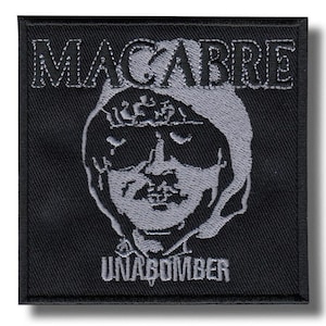 May include: Black square patch with the word "MACABRE" above a stylized, gray image of a person's face and the word "UNABOMBER" below. The patch has a black border and a white stitched design.